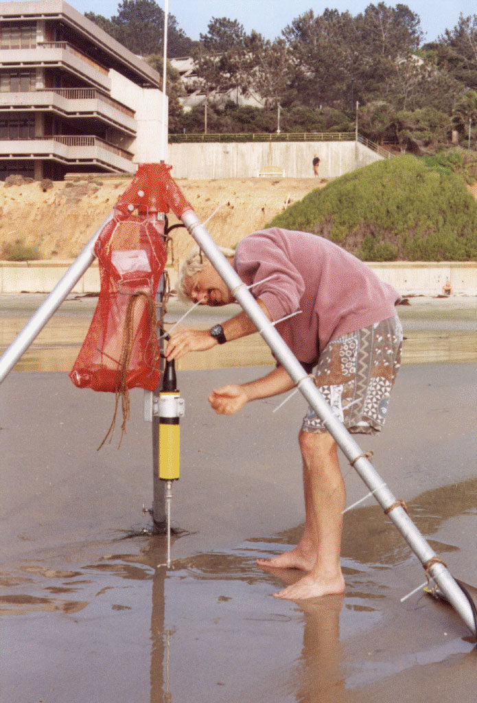 During low tide, Steve Elgar vertically adjusts a velocimeter to maintain approximately constant elevation above the beach surface.